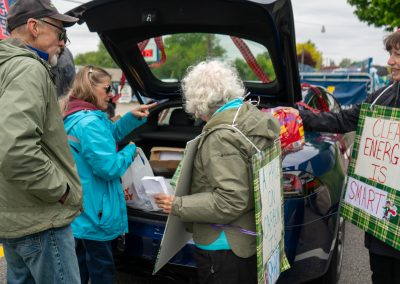 Group of protestors holding a sign at Mt Pleasant Citizens Climate Lobby at Alma Highland Festival 2026 3
