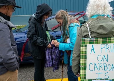 Group of protestors holding a sign at Mt Pleasant Citizens Climate Lobby at Alma Highland Festival 2026 8